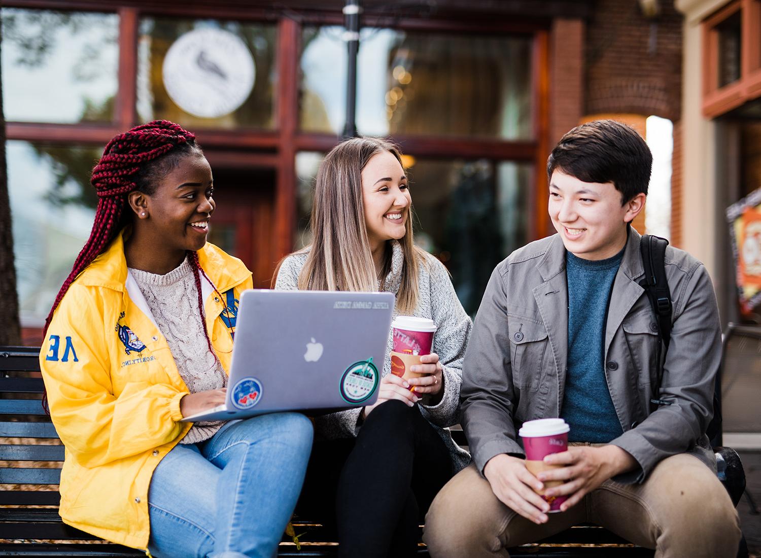 Students sitting outside studying with coffee on the Carrollton square.